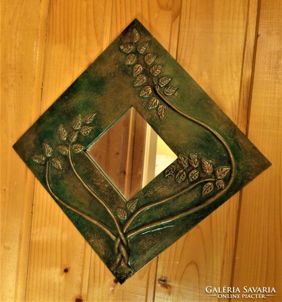 Decorative small mirror, decorated with copper tendrils, on a painted wooden sheet / 