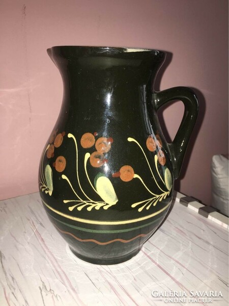 Dark brown glazed ceramic jug with flower pattern