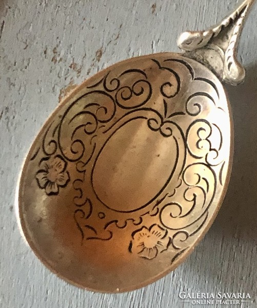 A specially decorated silver spoon with a unique shape