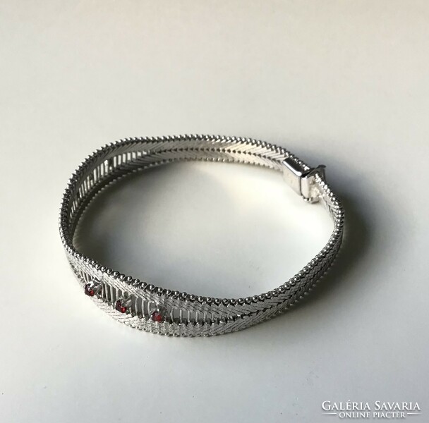 Brand new silver bracelet decorated with red stones