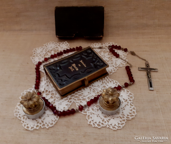 Old nun's heirloom prayer book with buckle, rosary on a lace tablecloth with a gift candle