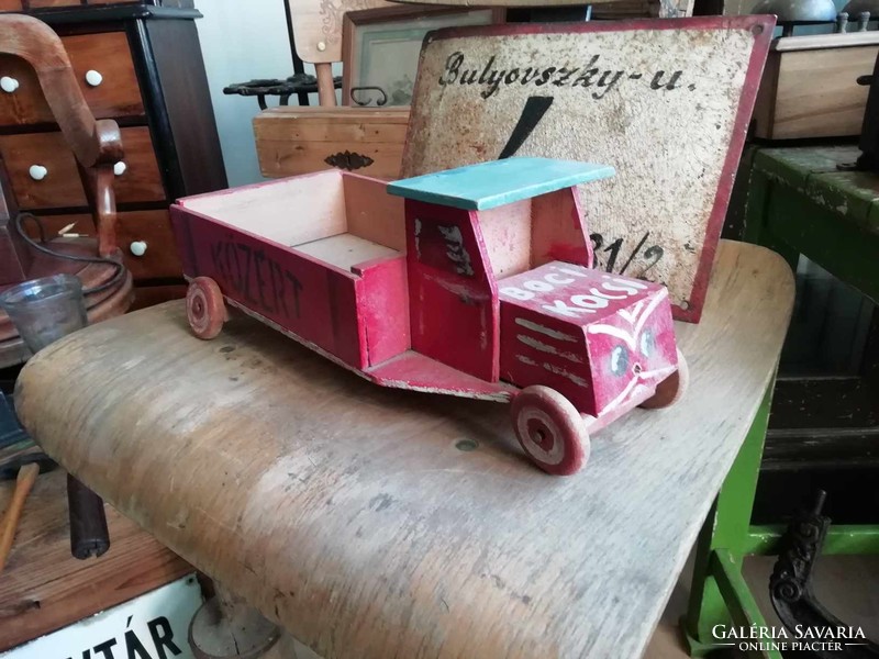 Wooden van from the 1960s with a public sign on the side and unique decoration, retro toy