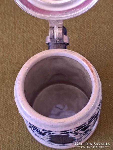 Mini blue patterned ceramic beer mug with opening cap on the top, the marking on the bottom is blurred