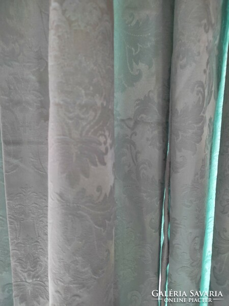 A pair of turquoise curtains embroidered in vintage material