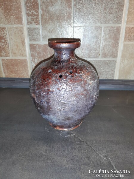 Old rustic glazed ceramic vase with decorative holes