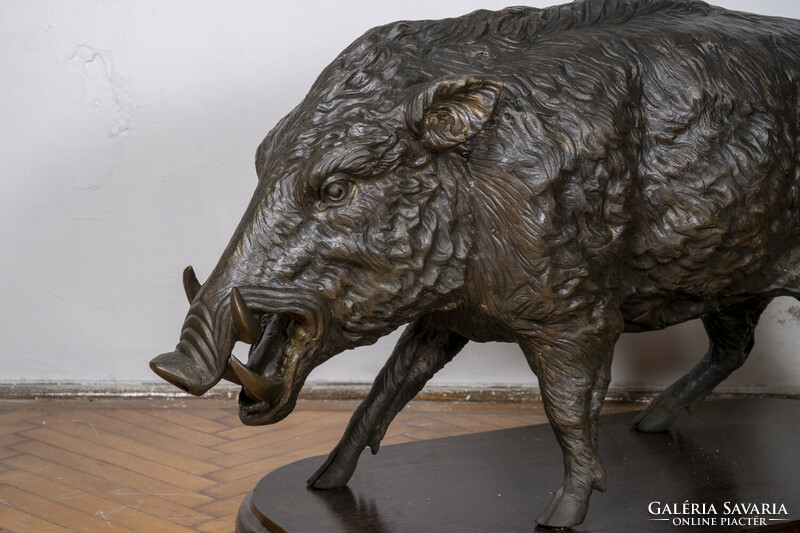 Large bronze boar statue on a wooden pedestal