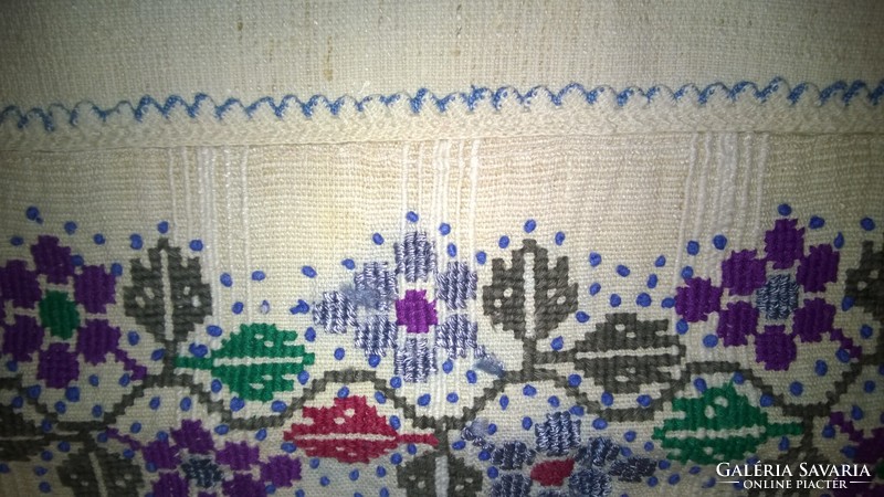 Traditional decorative pillow on home linen with cross-stitch needlework, a beautiful piece.