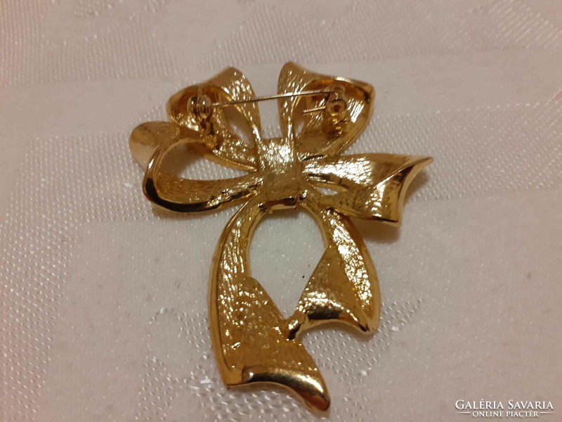 Gold-colored, bow-shaped brooch in good condition