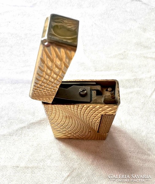 A gold-colored abstract patterned lighter from an Inke Lászl legacy