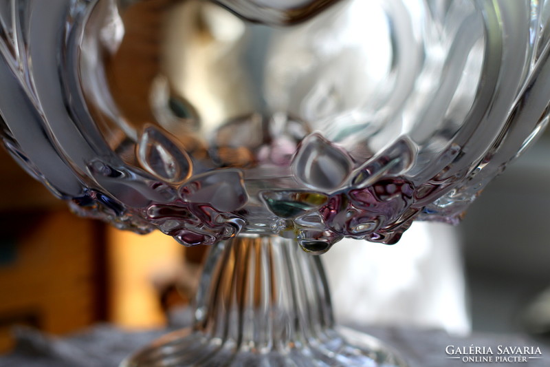 A beautiful cast glass pedestal table centerpiece with colored flowers and blown rim