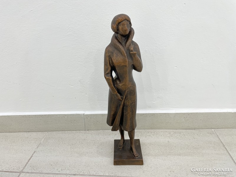 Resin statue of a female figure with a sign