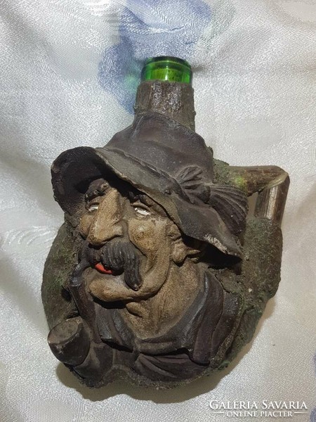 Old human face, old bottle with figural representation.
