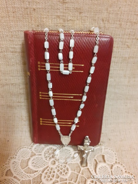 Old German language leather bound prayer book with gilt edges and mother of pearl rosary on lace tablecloth together