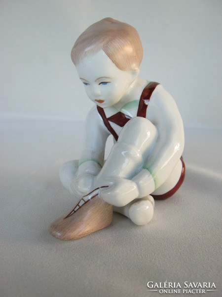 Aquincumi porcelán cipőt húzó kisfiú
