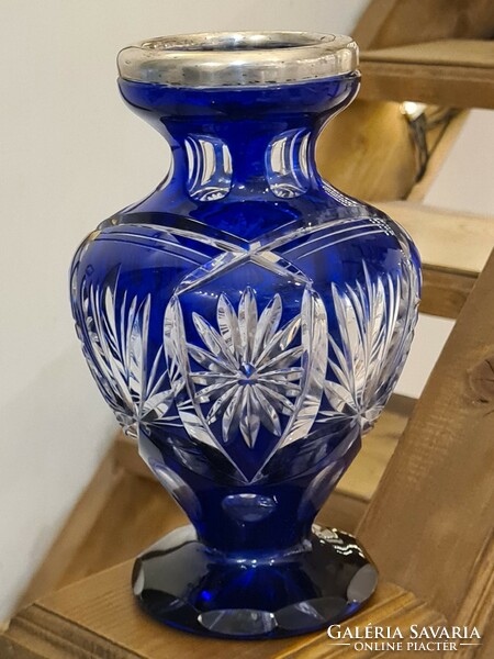 A polished blue old glass vase with a silver rim