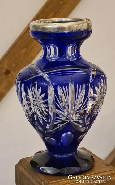 A polished blue old glass vase with a silver rim
