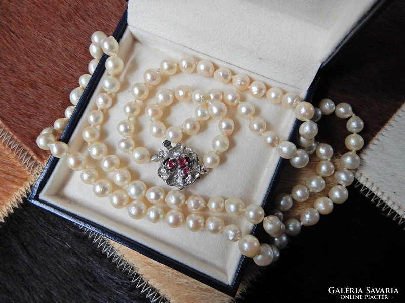 Old genuine semi-baroque string of pearls with modernist silver clasp and ruby stones