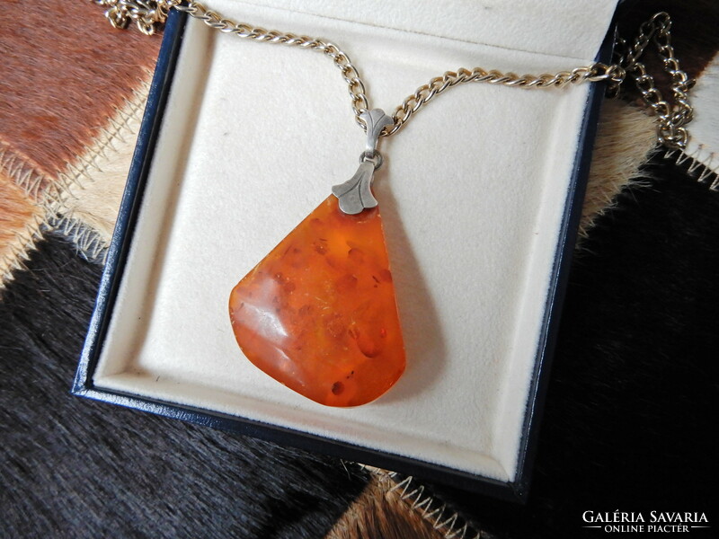Old silver pendant with amber on a gold-plated chain