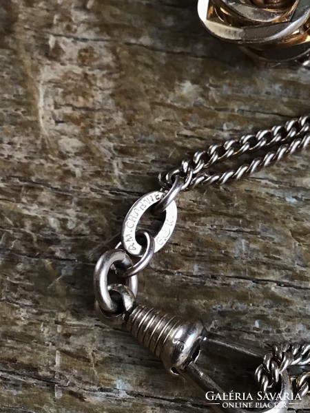 Old gilded pocket watch chain with small decoration.