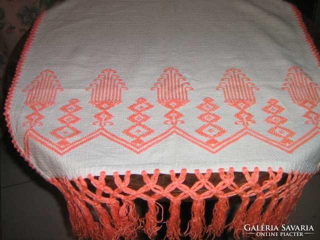 Beautiful hand-embroidered fringed woven tablecloth or towel on a white background