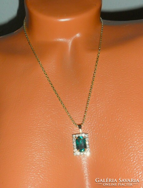 Pendant with green polished stone and rhinestones on a gold-colored chain.
