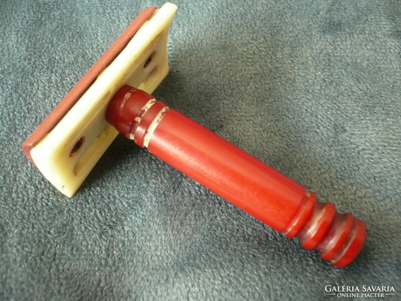 Old plastic travel safety razor with a red handle