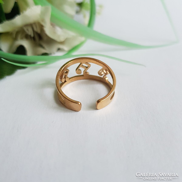 New, gold-colored, dimensionless ring decorated with engraved musical notes