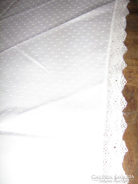 Beautiful white damask tablecloth with a lacy circle with shiny spots