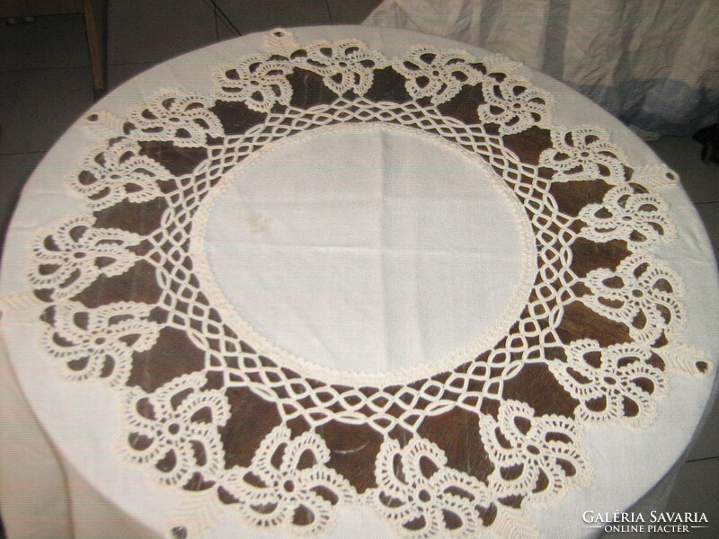 A cream-colored tablecloth with a beautiful hand-crocheted flower insert