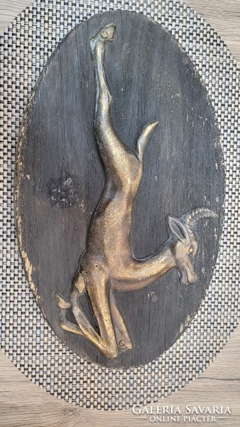 Vintage jumping chamois made of copper on a wooden base. Wall decoration.