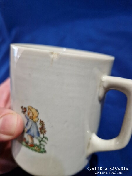 An old Zsolnay porcelain mug depicts two little girls, a fairy mug with a scene