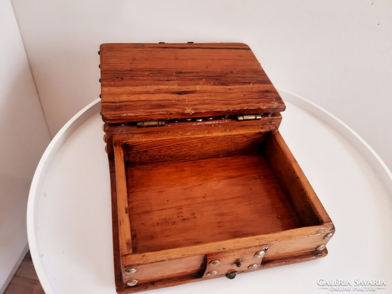 A wooden box with a buckle in the shape of a book
