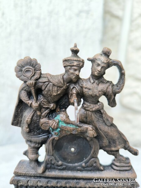 A beautiful figural bronze statue on a wooden base holding a pocket watch. Eastern Asian sculpture dancing figures