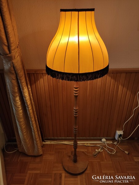 Retro floor lamp with a fringed shade that emits a cozy warm light 