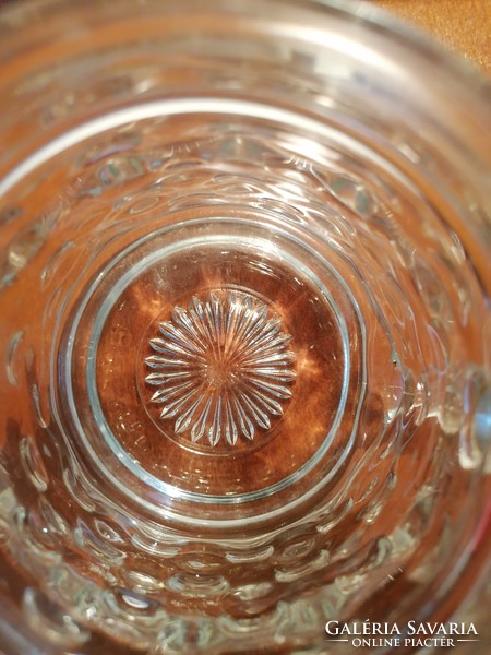 Üvegtestű, anyagában kidomborodó söröskorsó, melynek ón fedele is domború mintázatú. Jelzett BMF.