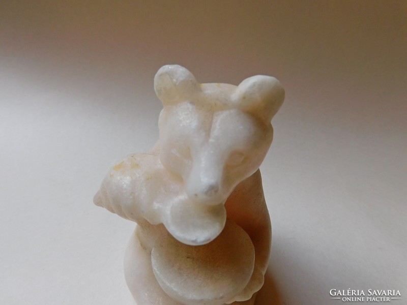 Stone carved bear figure scooping honey