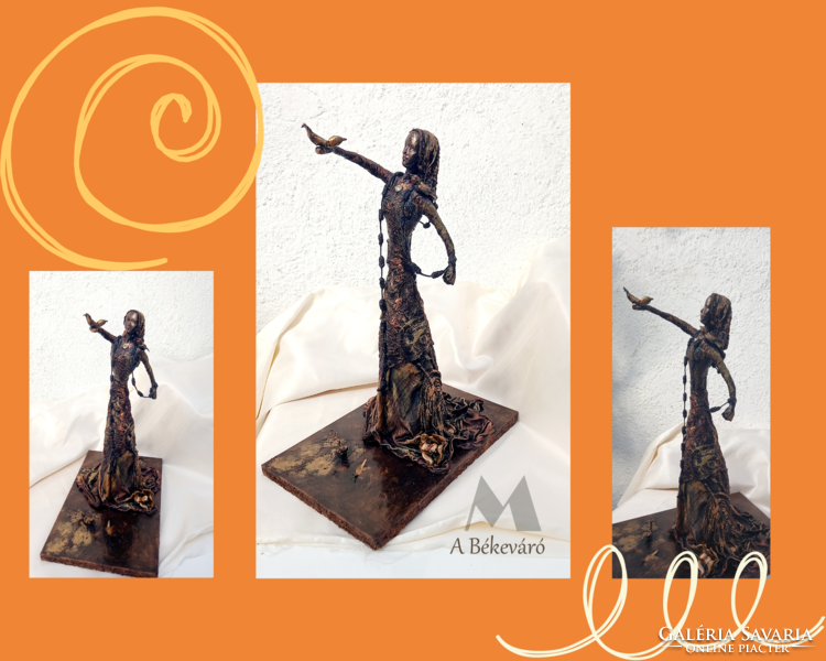 The handcrafted textile sculpture waiting for peace is made of recycled materials and is black-bronze in color