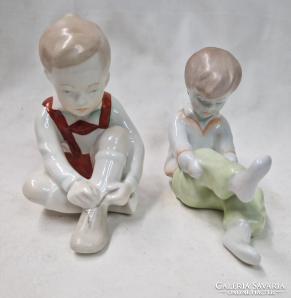 Porcelain figurines of a boy and girl tying Aquincumi's shoes are sold together in perfect condition