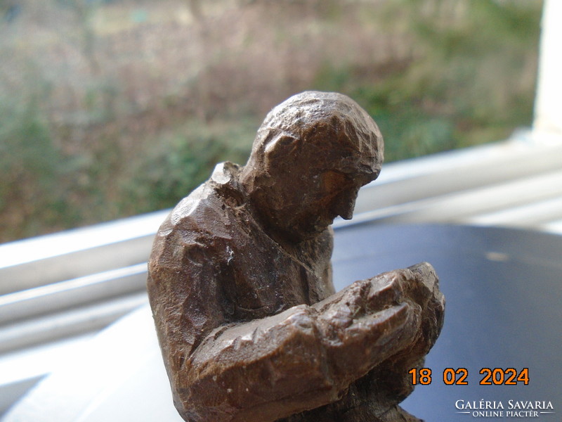 Small sculpture of a man engrossed in reading