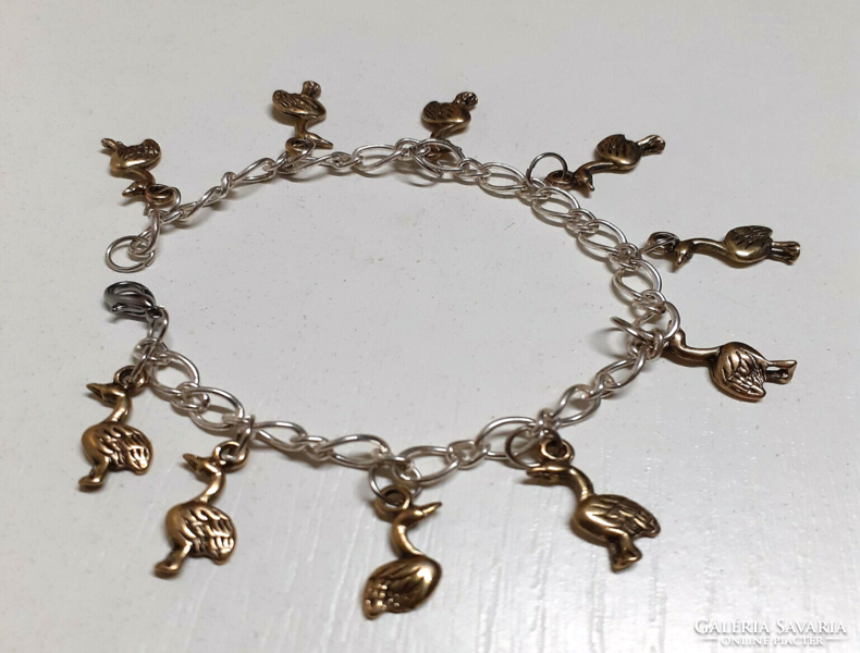 A beautiful silver-colored stainless steel bracelet decorated with small gold-plated birds