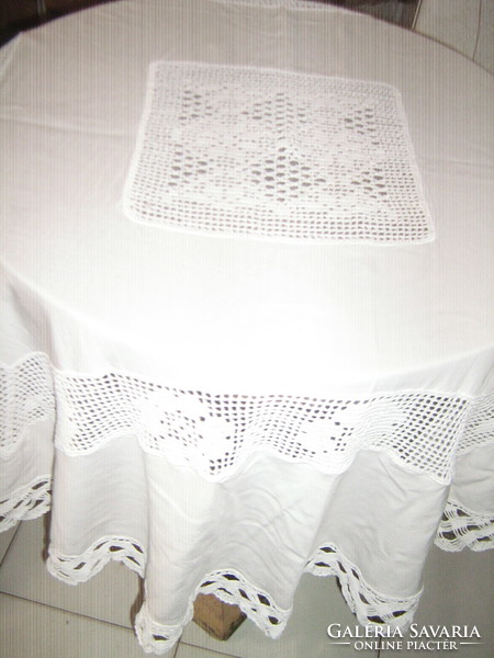 Beautiful white hand-crocheted round tablecloth with a crocheted flower insert