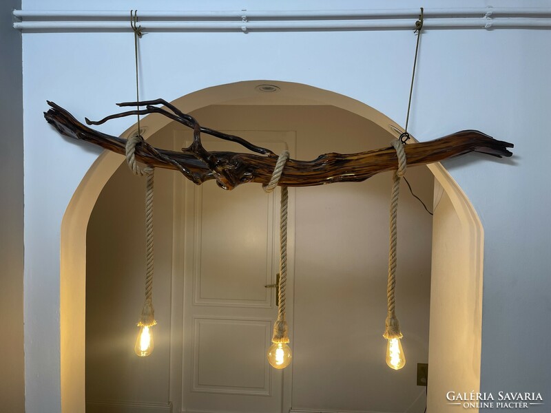 A unique ceiling lamp hanging on a chain made of yew roots,