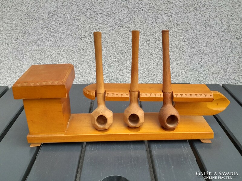 Pipe holder with carved wooden pipes