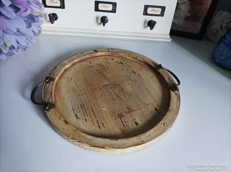 With a diameter of 30 cm, a rustic, worn round wooden tray with copper handles