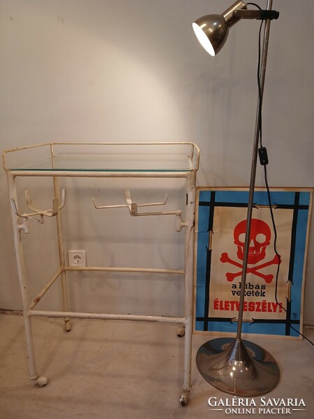 Old medical metal table on castors with fold-out tray holders