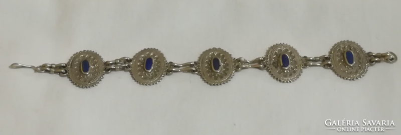 Metal bracelet with blue stones.