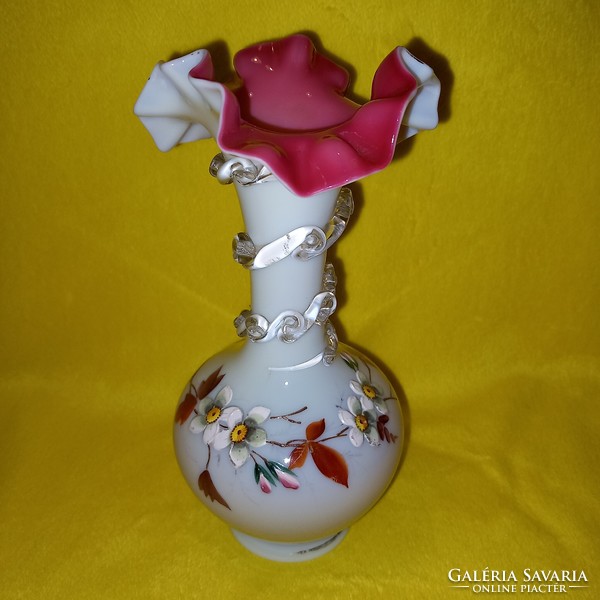 An old, antique glass vase with a frilled mouth and a broken bottom.