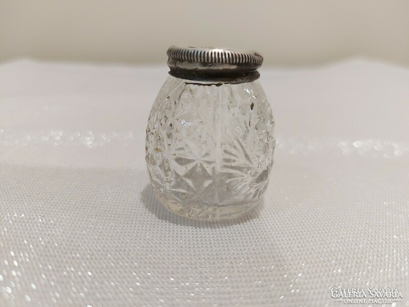 Polished glass salt and pepper shaker with old silver lid.
