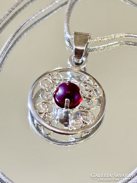 A beautiful silver necklace and pendant, embellished with a garnet stone