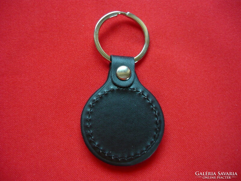 Peugeot metal keychain on a leather background
